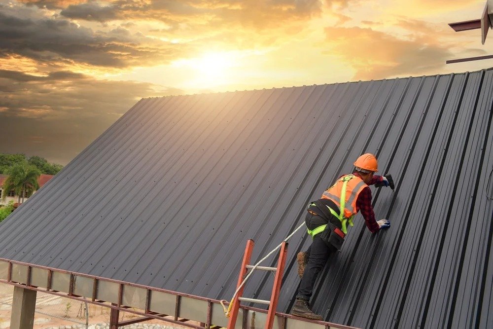 A man is climbing a ladder to work on a roof, wearing safety gear and focused on his task.